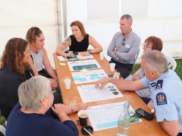 Community support agencies, Police, regional leaders and mana whenua taki sat at a table during a workshop at the launch