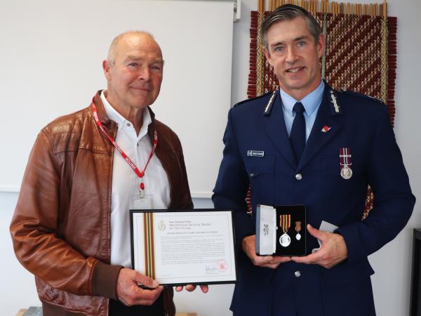 Senior Sergeant (retired) Mark Davidson receiving the Meritorious Service Medal from Commissioner Andrew Coster.