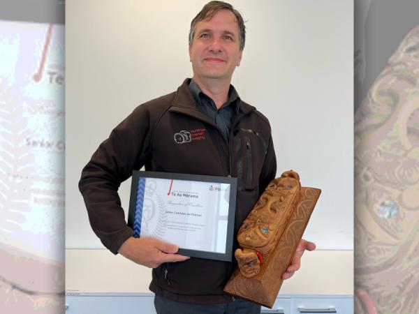 Forensic photographer Ian Pearson holding his award. 