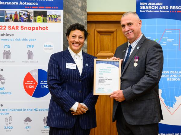 Minister Kiri Allan presents Detective Senior Sergeant John Wilson with his award.