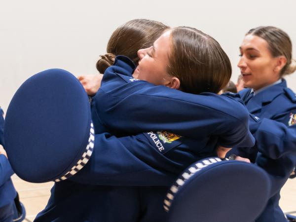 Wing 366 constables hugging after their graduation.