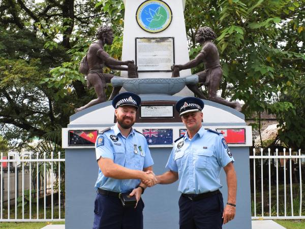 Inspector Warwick McKee shaking hands with medal recipient Sergeant Dave Nichols at the RAMSI monument.