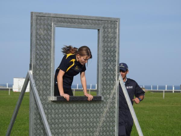 One of the participants jumping through a window obstacle as part of the Police PCT.
