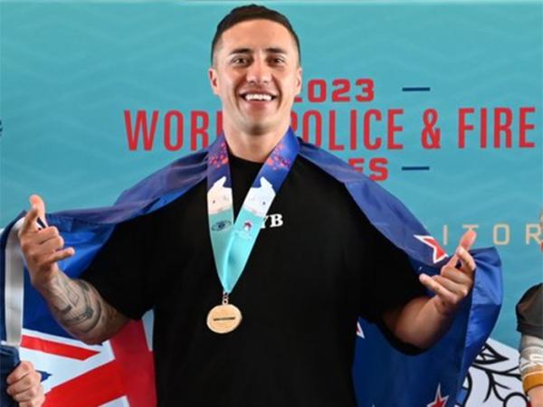 Constable Tyson Ripia wearing his gold medal on the podium at the 2023 World Police and Fire Games.
