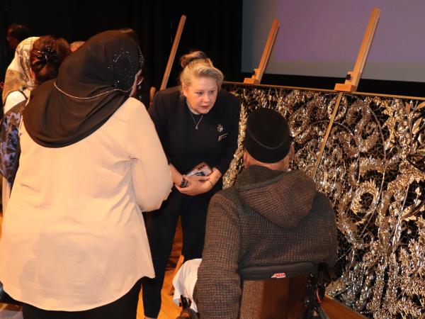 The artist, Anisa Sharif, explaining the meaning behind the stunning artworks to members of the Muslim community.. 
