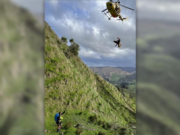 A paramedic being winched to the helicopter with the injured hunter on a stretcher.