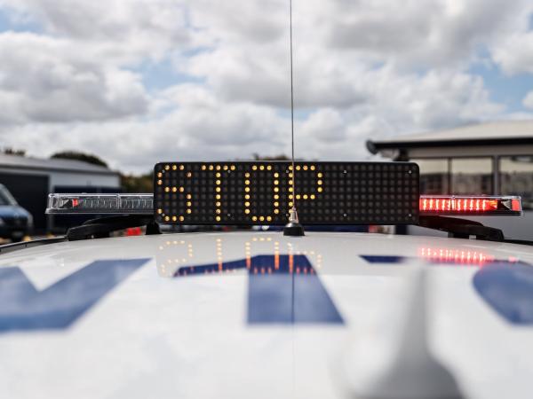 Stop written in lights on top of a police patrol car 