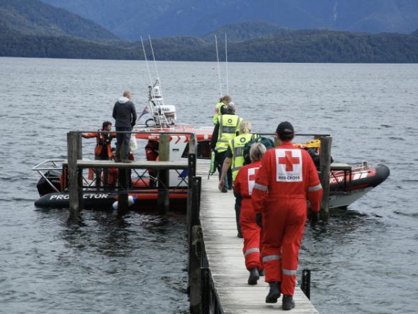 Responders walking out on a jetty to a boat.