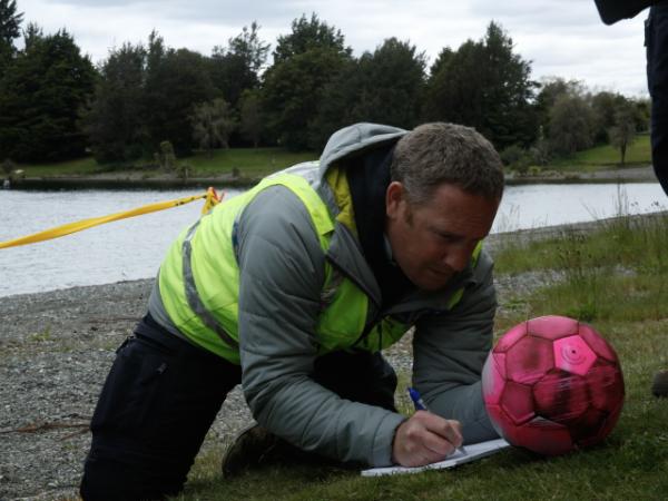 Senior Sergeant Blair Dalton tends to a football 'victim' on the shore and records vital information for the IMT.