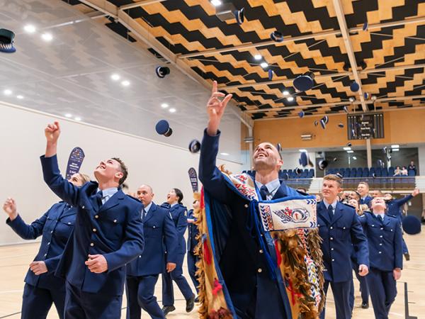 The newly graduated constables throwing their hats in the air.