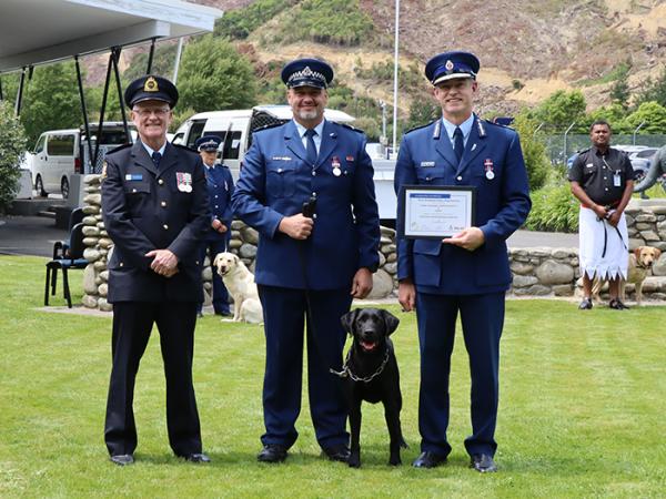 Senior Constable Lyal Bayliss and detector dog Luther receive their graduation certificate from Commissioner Andrew Coster....
