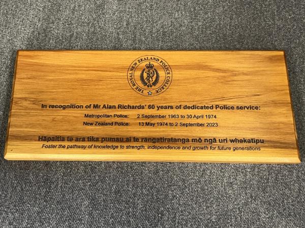A photo of the rimu plaque that was gifted to Alan Richards, detailing the dates of his police service in the UK and New Zealand