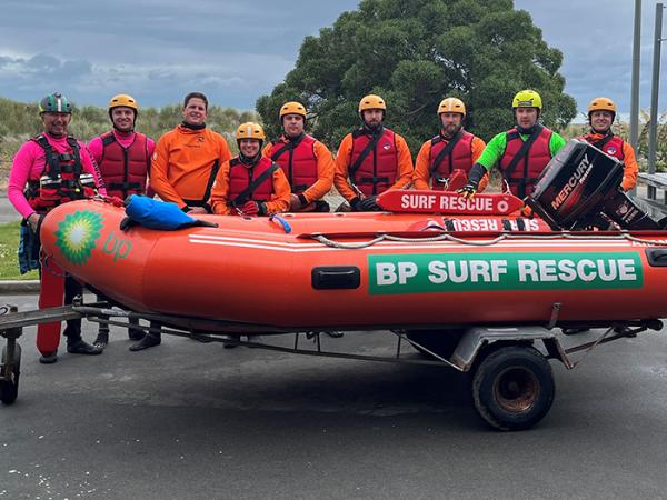 Constable Tom Denman, third from left, members of Taylors SLSC, left, and fellow Police staff in front of a Surf Rescue rhib. 
