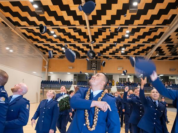 Wing 371 throwing their hats in the air after being dismissed from parade at their graduation. 