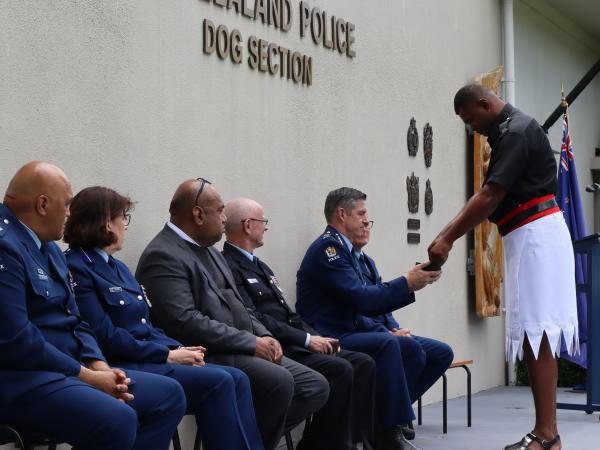 Constable Sailasa Kerekere pouring kava into a bowl being held out by the Commissioner during the kava ceremony.