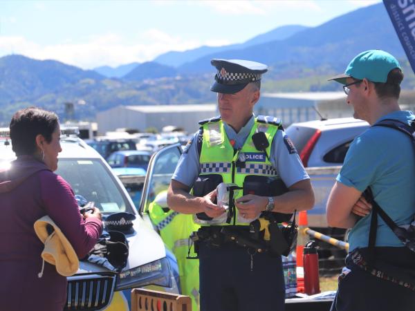 A police officer in uniform and wearing a high-vis vest chatting to members of the public at the event.
