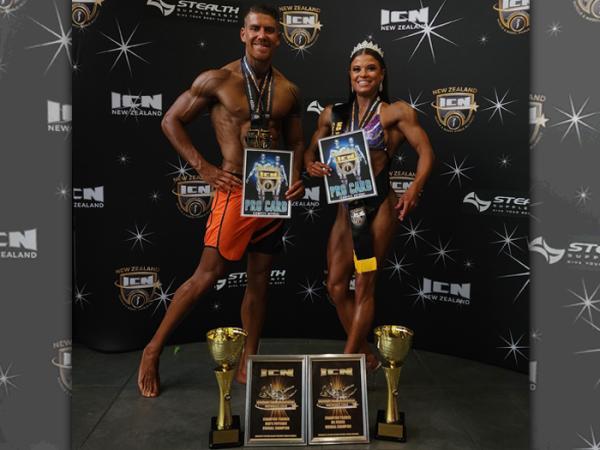 Shane and Michelle pictured with their pro cards after a competition.