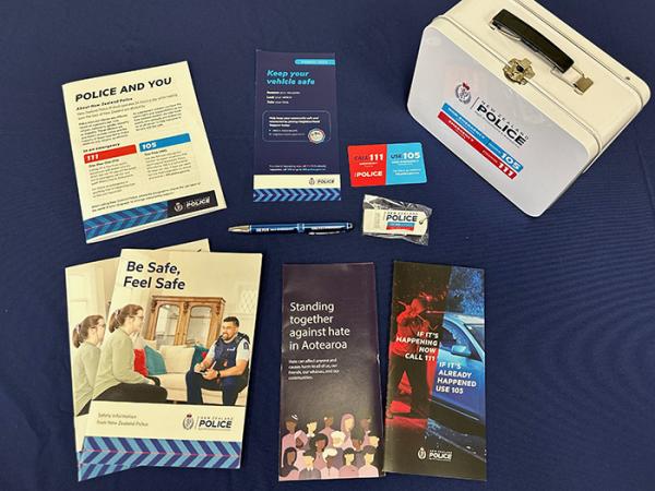 A layout photo of some of the items in the welcome pack, including the Police-branded lunchbox, pen, magnet and safety leaflets