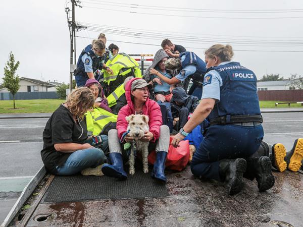 Police staff help evacuate people in Taradale during Cyclone Gabrielle. Photo: Hawke's Bay Today