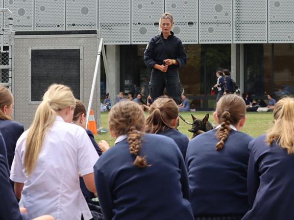 Students listening to a trainee dog handler. 