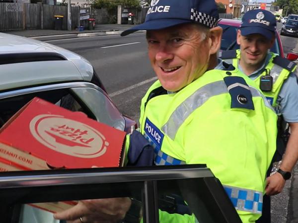 Campus Cop John Woodhouse with pizzas.