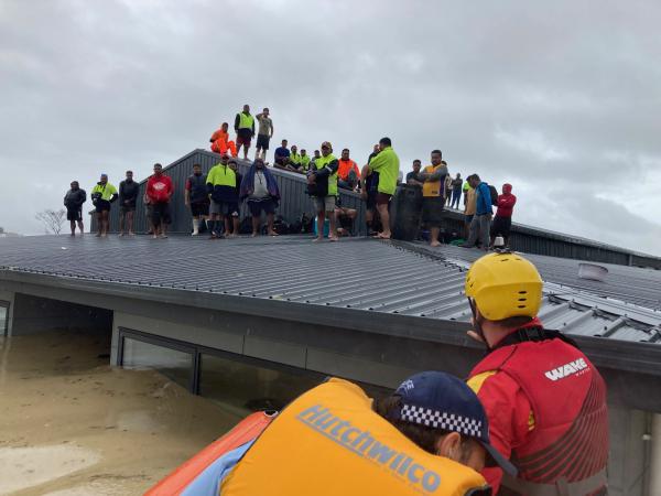 RSE workers waiting to be rescued from a rooftop after Cyclone Gabrielle hit Hawke's Bay last year.