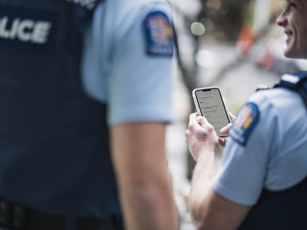 An officer in uniform using their device.
