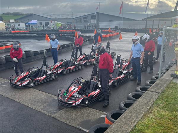 Police and Fire and Emergency New Zealand staff standing next to their go-karts before the race.