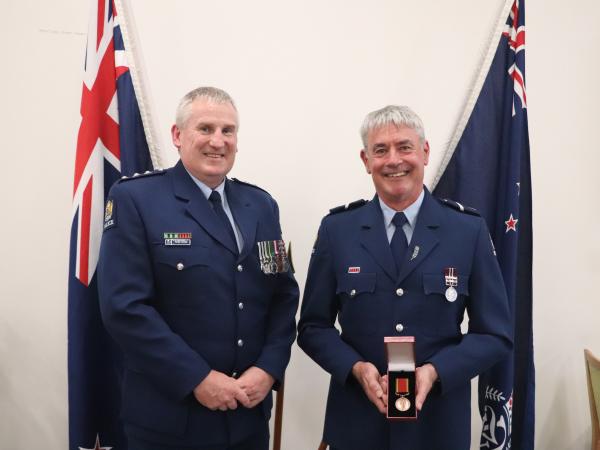 Rural Area Commander Inspector Peter Cooper presenting Senior Constable Tony Maw with his award.