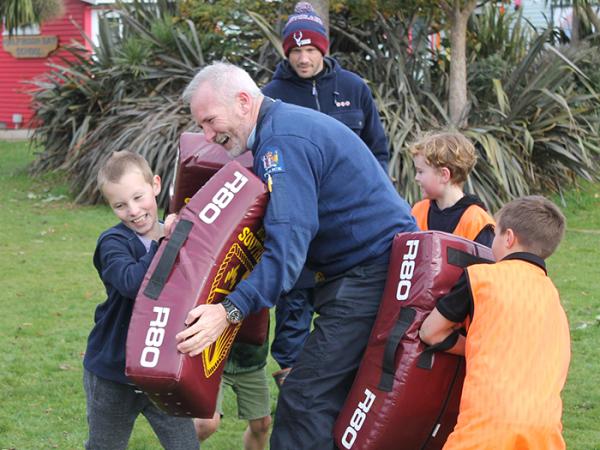 Rakiura Sole Charge Officer Stuart Newton in the thick of Halfmoon Bay School's rugby coaching clinic. PHOTOS: Rugby Southland.