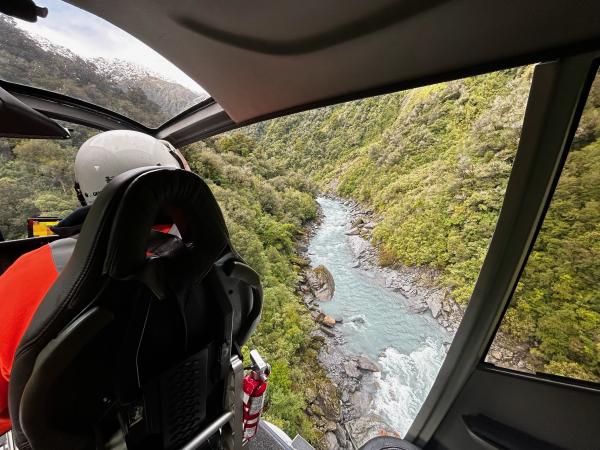 A helicopter searches for a missing man in the dense bush bordering the Hokitika River.