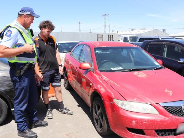 Constable Mark Catley and Christian Karatau from Trade Towage inspect an impounded car.