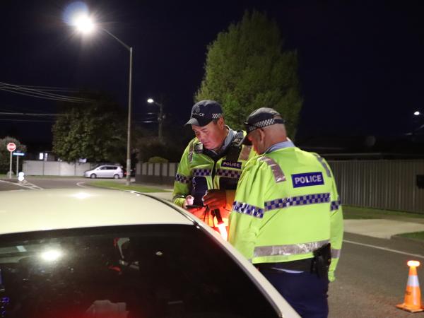 Constable Mark Catley and Sergeant Damien Gordon speak with a driver at a checkpoint.