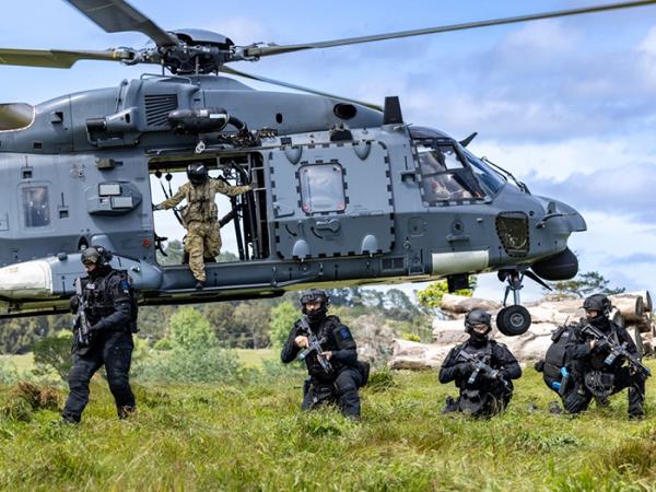 AOS advance with the NH90 taking off behind them. Photo: Tāmaki Makaurau Police Forensic Photographer Alex Stammers.