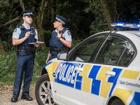 Police staff by car in bush location