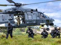 AOS advance with the NH90 taking off behind them. Photo: Tāmaki Makaurau Police Forensic Photographer Alex Stammers.